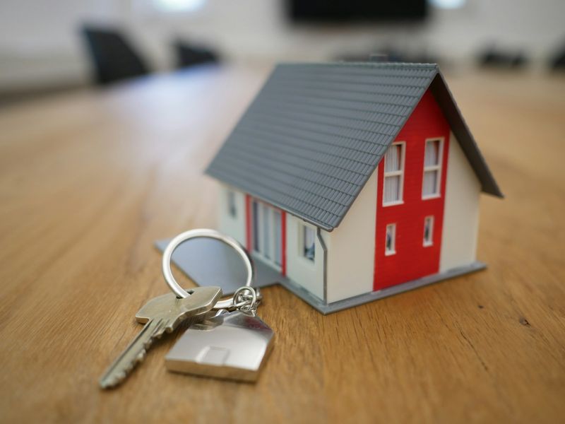 Maquette de maison posée sur une table à côté d'un trousseau de clés
