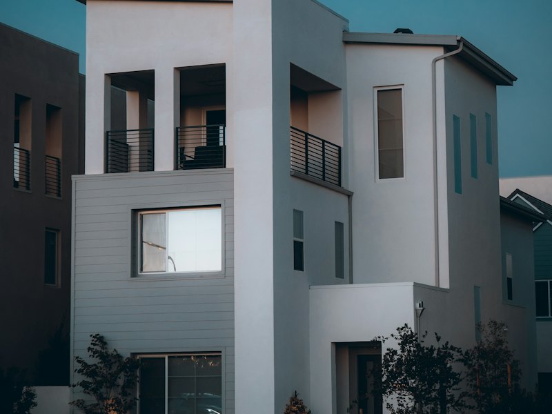 Maison contemporaine neuve aux façades blanches avec balcons